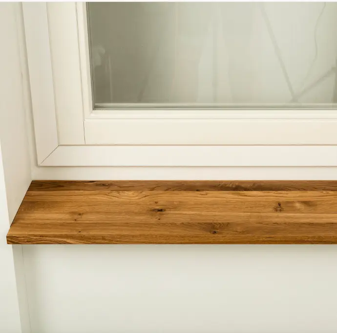 Custom wooden window sill providing charm and a sturdy display in a bright interior.